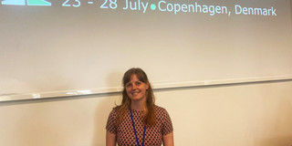 Laura Wuttke steht vor dem Schriftzug der HCI International 2023